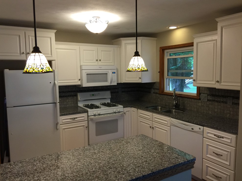 Eat-in kitchen - small transitional l-shaped eat-in kitchen idea with an undermount sink, raised-panel cabinets, white cabinets, granite countertops, gray backsplash, porcelain backsplash, white appliances and a peninsula