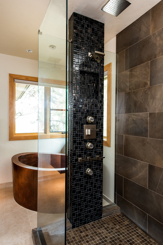 Inspiration for a mid-sized rustic master black tile and ceramic tile porcelain tile freestanding bathtub remodel with flat-panel cabinets, medium tone wood cabinets, beige walls, an undermount sink and solid surface countertops