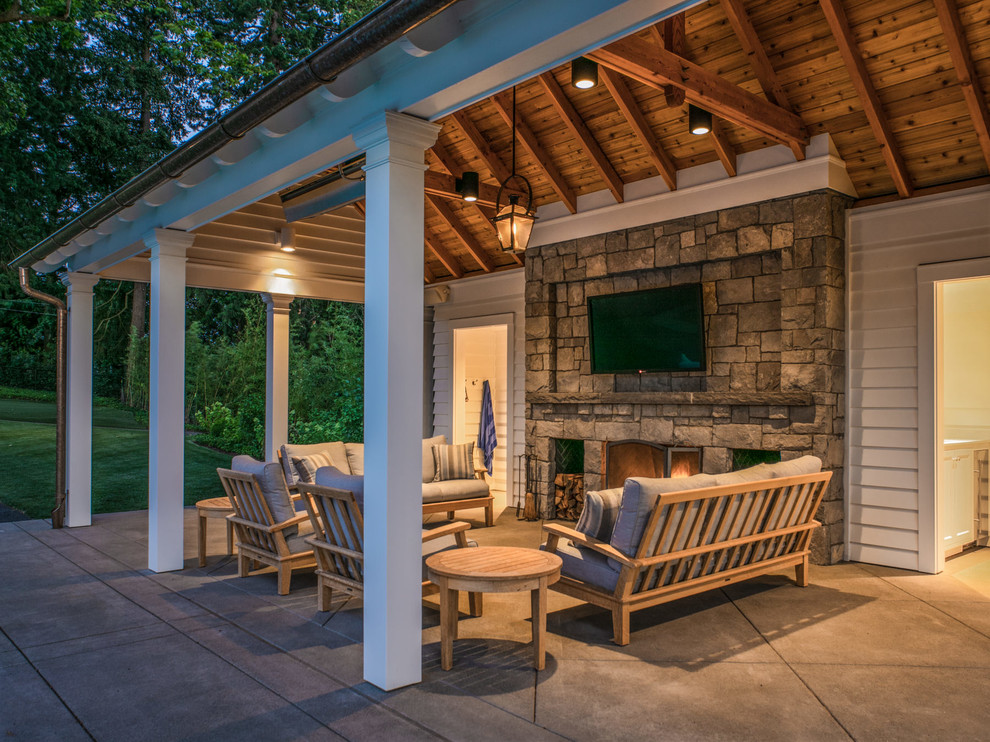 This is an example of a large traditional backyard patio in Portland with with fireplace, concrete slab and a gazebo/cabana.