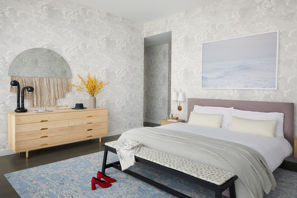 Imagen de dormitorio principal y gris actual grande sin chimenea con suelo de madera en tonos medios, papel pintado, paredes grises y suelo marrón