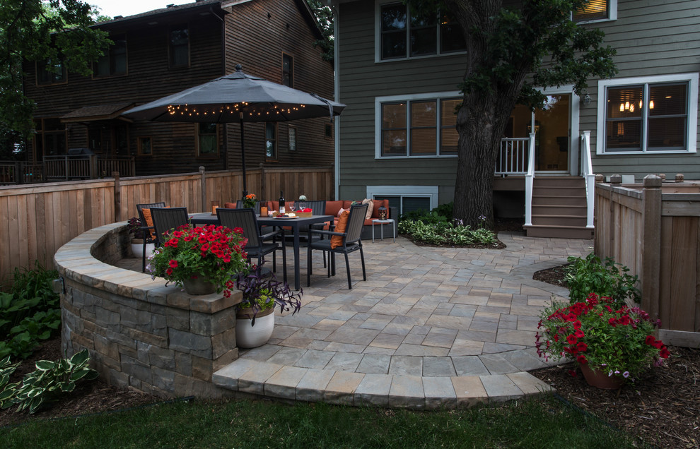 This is an example of a small contemporary backyard patio in Minneapolis with brick pavers.