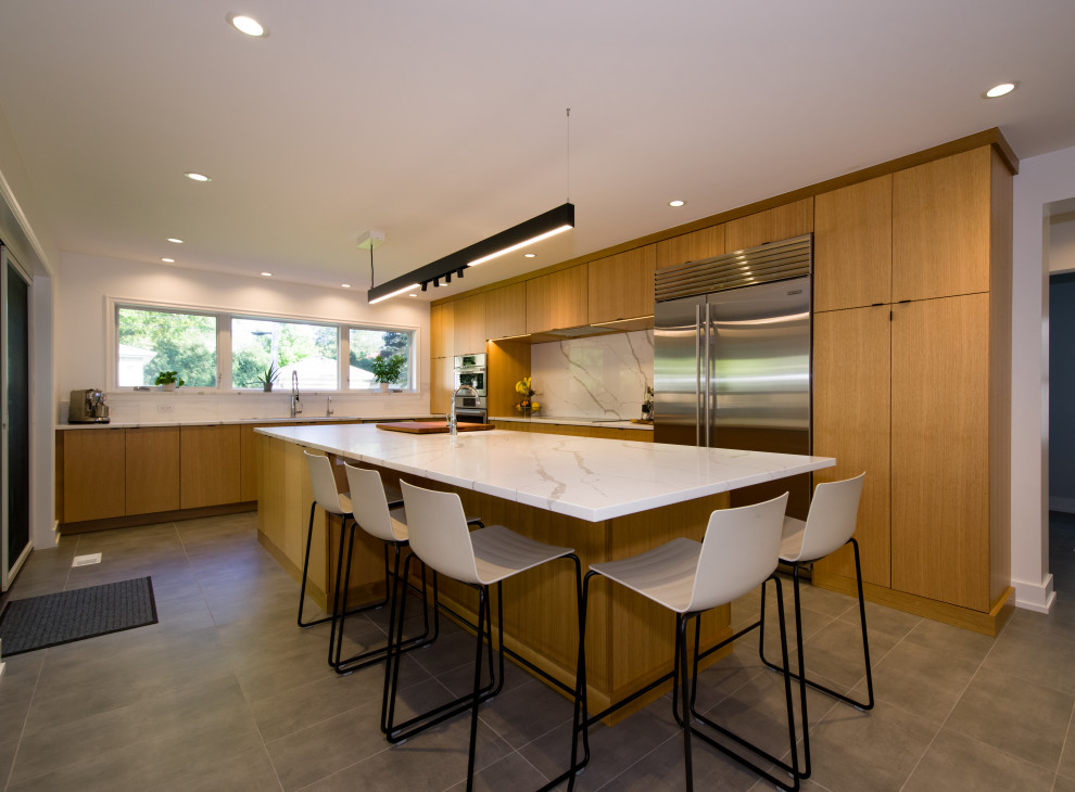 Large modern l-shaped separate kitchen in Chicago with flat-panel cabinets, light wood cabinets, marble benchtops, white splashback, stone slab splashback, stainless steel appliances, porcelain floors, with island, grey floor and white benchtop.