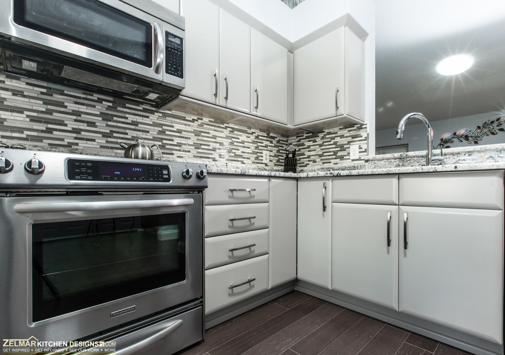 Inspiration for a small contemporary l-shaped eat-in kitchen in Orlando with an undermount sink, flat-panel cabinets, grey cabinets, granite benchtops, multi-coloured splashback, mosaic tile splashback, stainless steel appliances and a peninsula.