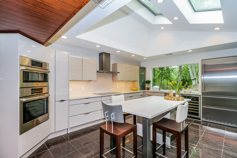 Photo of a mid-sized contemporary eat-in kitchen in Denver with flat-panel cabinets, white cabinets, quartz benchtops, stainless steel appliances and with island.