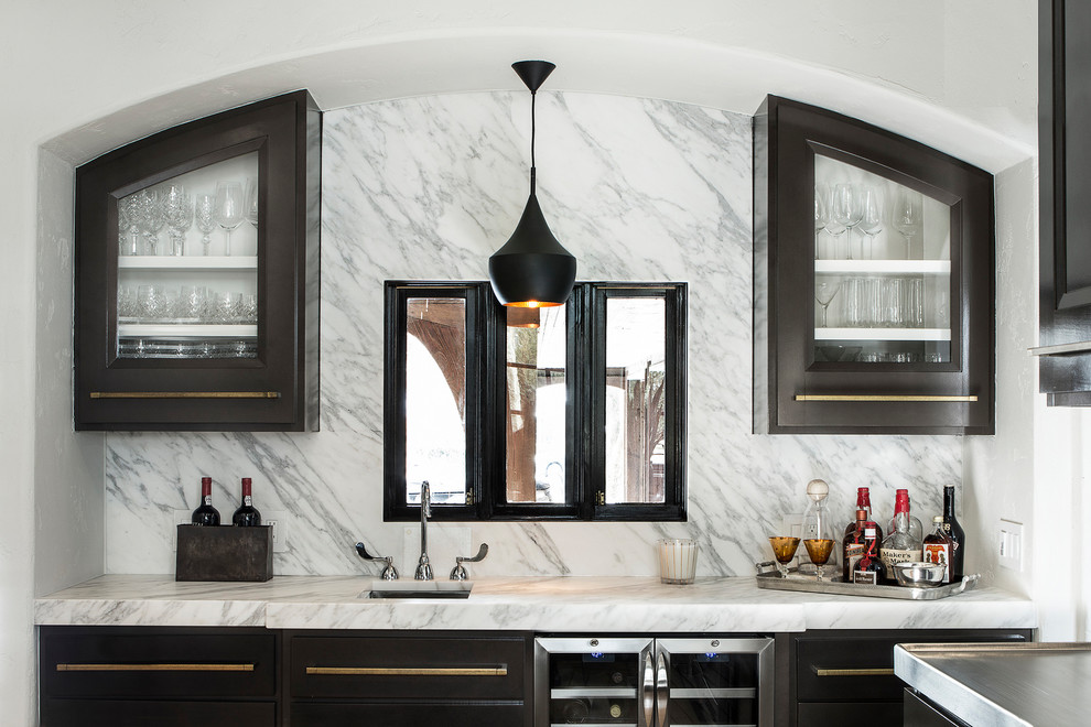 Photo of a mid-sized transitional single-wall wet bar in Other with brown cabinets, marble benchtops, multi-coloured splashback and marble splashback.