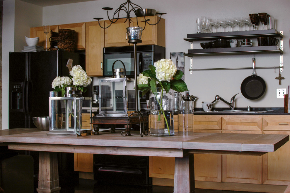 Eclectic kitchen in Dallas with light wood cabinets and black appliances.