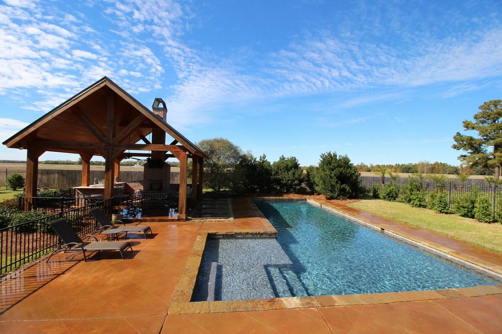 Pool - large rustic backyard concrete paver and rectangular lap pool idea in New Orleans