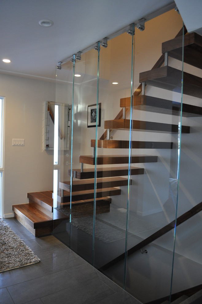 This is an example of a mid-sized contemporary wood u-shaped staircase in Calgary with open risers.