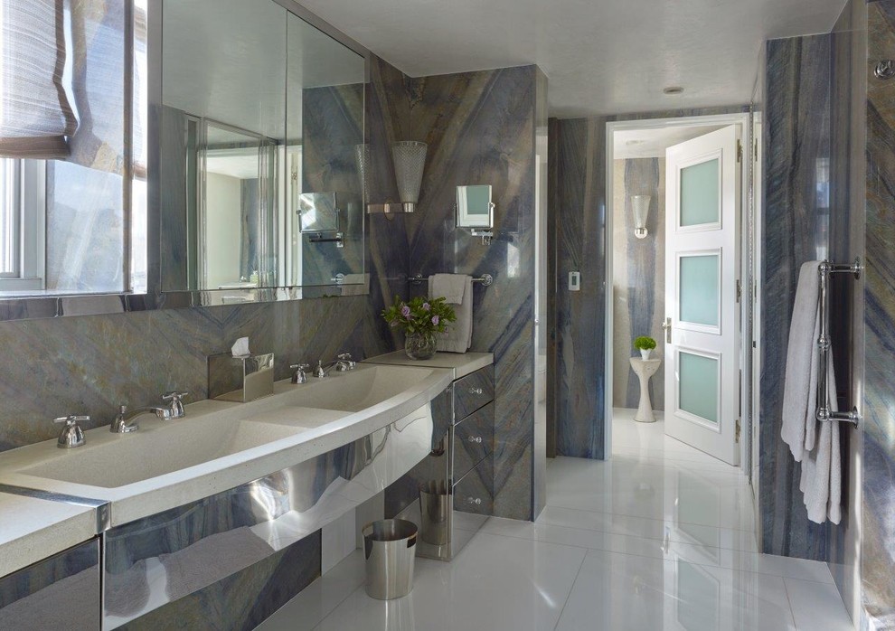 Photo of a contemporary master bathroom in New York with marble floors, solid surface benchtops, an integrated sink, stone tile, multi-coloured walls and flat-panel cabinets.