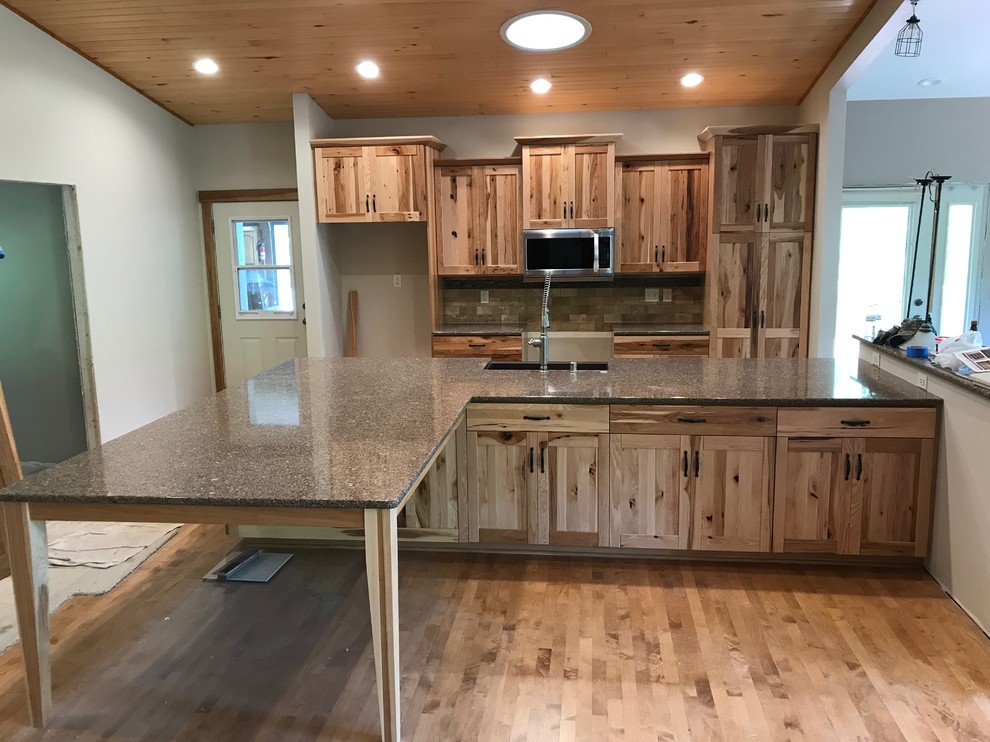 Example of a mid-sized mountain style galley eat-in kitchen design with an island