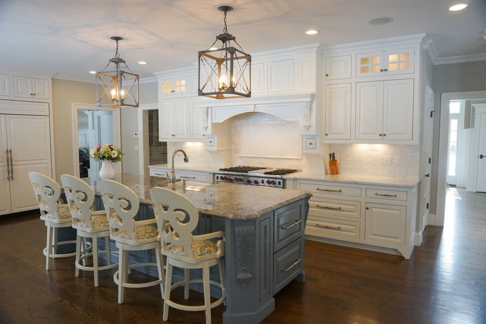 Inspiration for a mid-sized traditional galley open plan kitchen in Boston with a farmhouse sink, raised-panel cabinets, white cabinets, granite benchtops, white splashback, subway tile splashback, stainless steel appliances, dark hardwood floors, with island and brown floor.