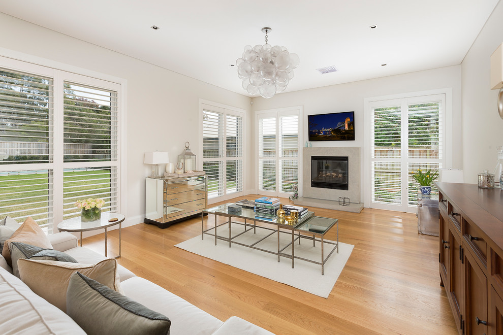This is an example of a large transitional formal open concept living room in Sydney with light hardwood floors, a standard fireplace, a tile fireplace surround and a wall-mounted tv.