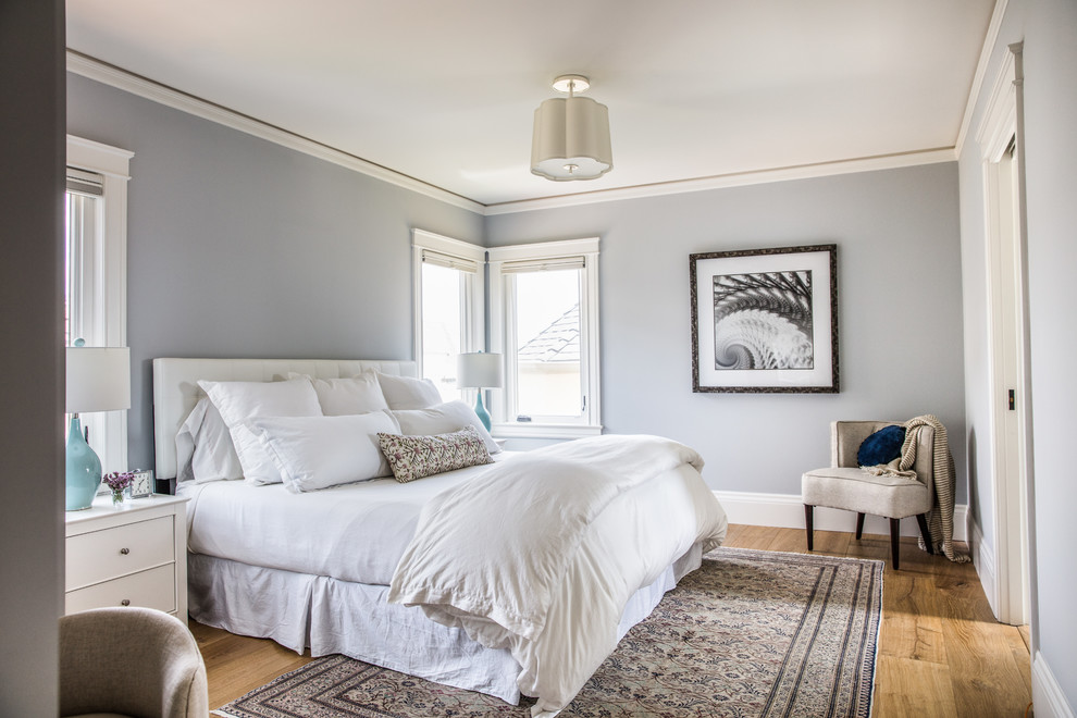 Inspiration for a mid-sized transitional bedroom in San Francisco with grey walls, medium hardwood floors and brown floor.