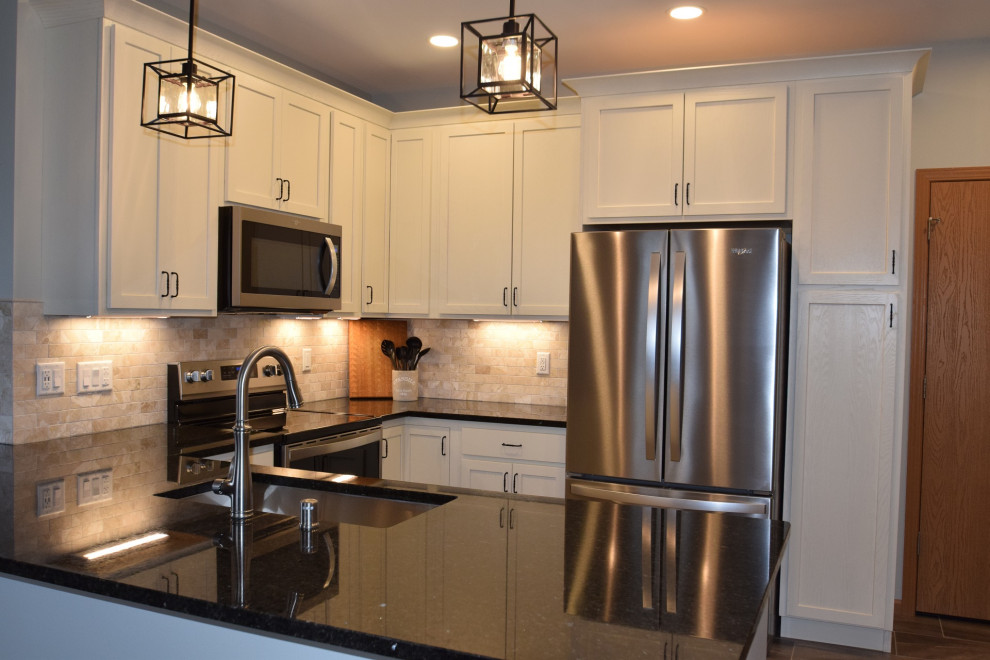 Kitchen - mid-sized transitional u-shaped vinyl floor kitchen idea with a single-bowl sink, shaker cabinets, white cabinets, quartz countertops, multicolored backsplash, stone tile backsplash, stainless steel appliances, a peninsula and black countertops