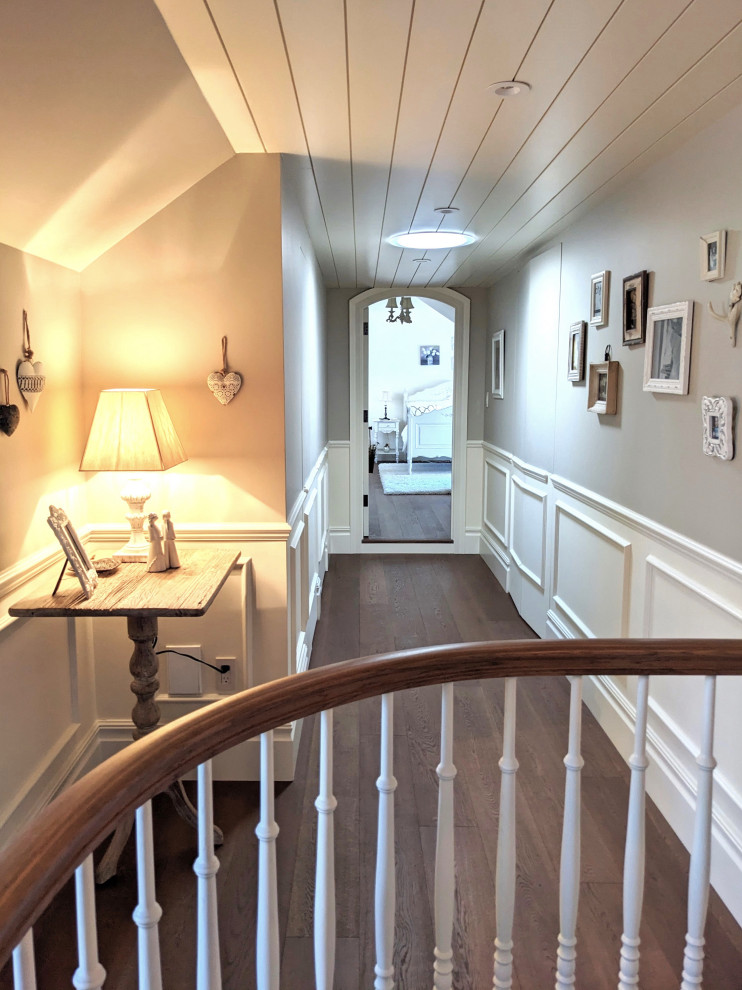 Imagen de habitación de invitados de tamaño medio con paredes blancas, suelo de madera en tonos medios, suelo marrón y boiserie