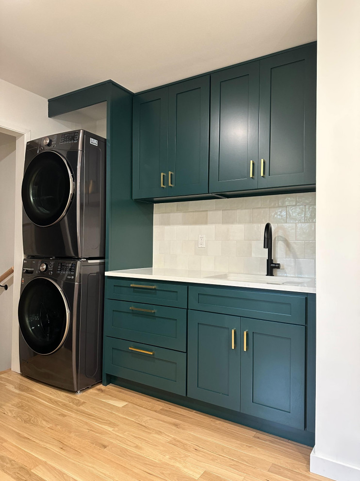 Design ideas for a laundry room in Seattle with green cabinets, white splashback and white walls.