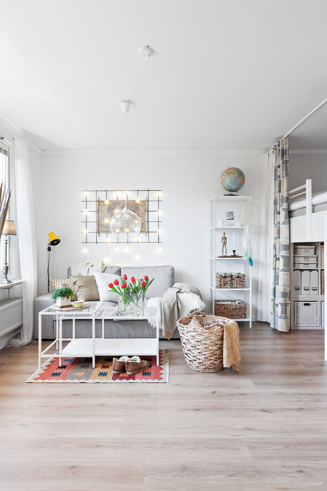 Scandinavian open concept family room in Other with white walls, light hardwood floors and beige floor.