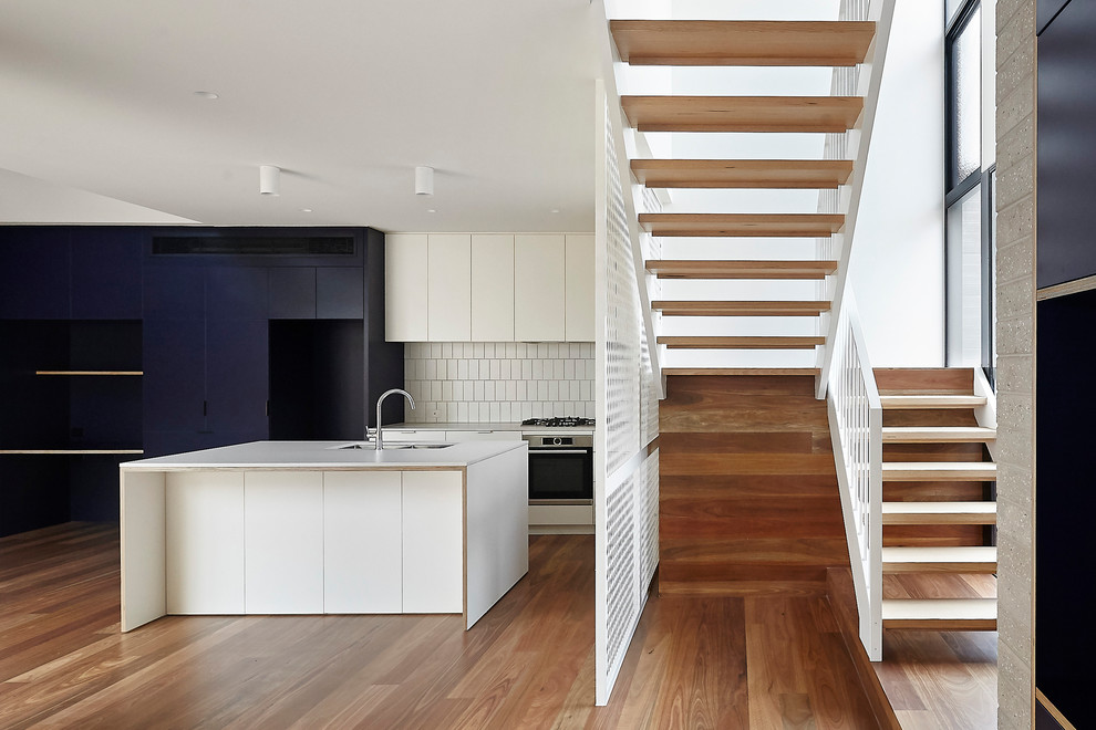 Mid-sized industrial wood u-shaped staircase in Melbourne with open risers and metal railing.
