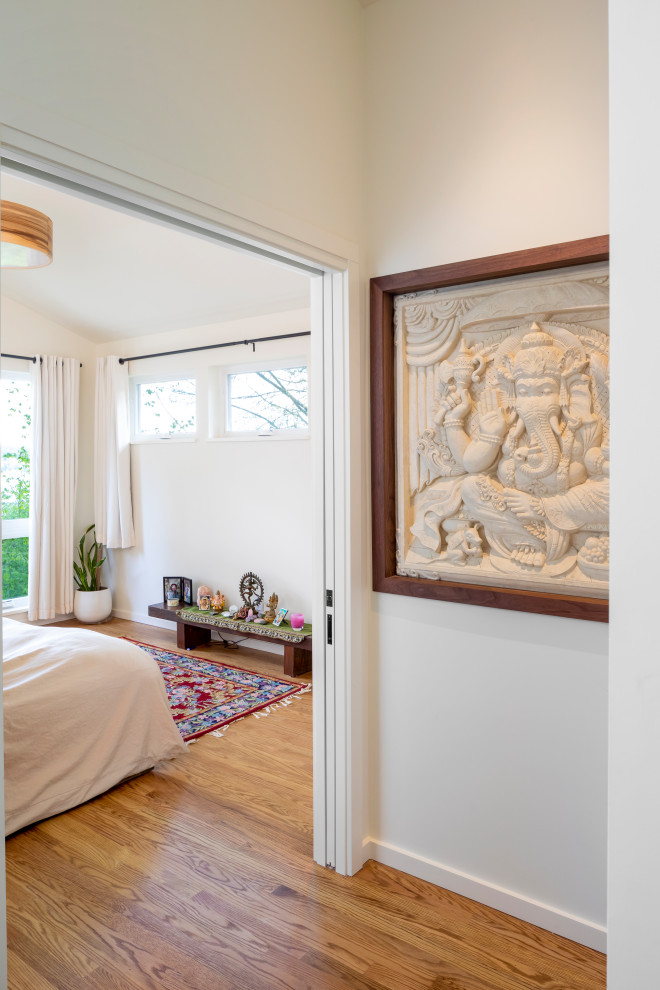 Photo of a medium sized contemporary master bedroom in Seattle with white walls, medium hardwood flooring and a vaulted ceiling.