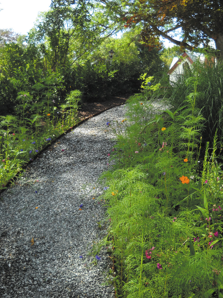 This is an example of a small country sloped partial sun xeriscape for summer in Providence with gravel.