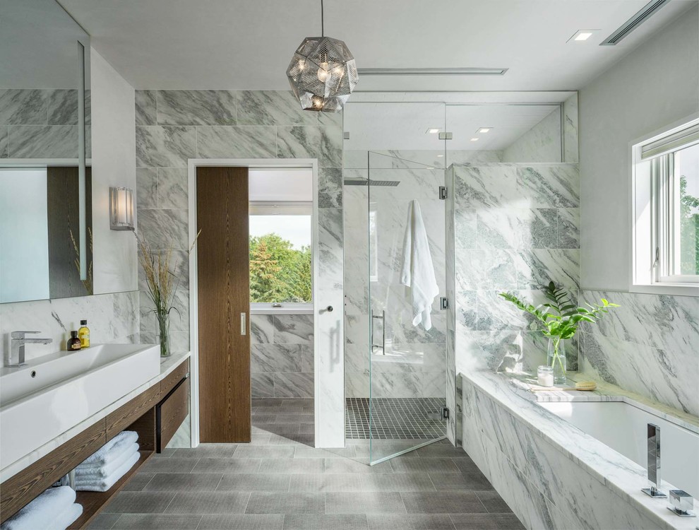 Contemporary bathroom in Burlington with flat-panel cabinets, dark wood cabinets, an undermount tub, an alcove shower, gray tile, a trough sink, grey floor and a hinged shower door.