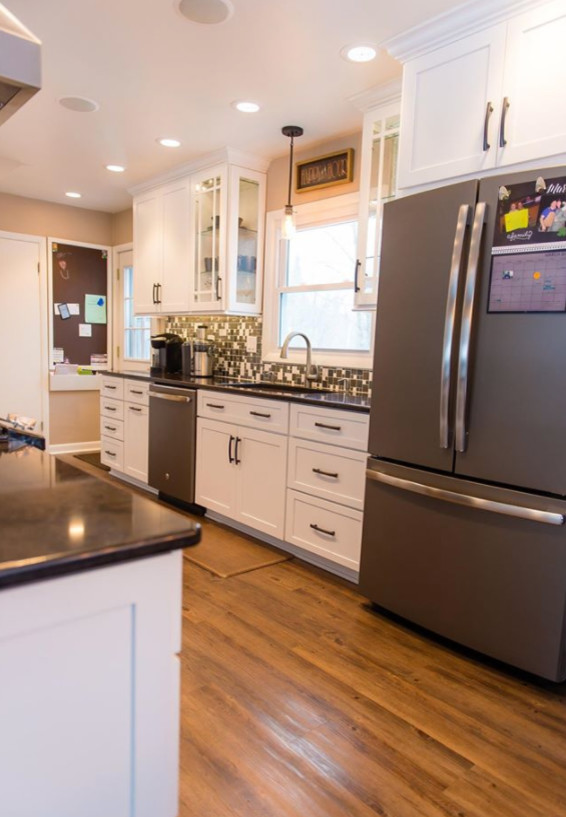 Mid-sized transitional galley medium tone wood floor and brown floor eat-in kitchen photo with shaker cabinets, white cabinets, a peninsula, an undermount sink, marble countertops, metallic backsplash, mosaic tile backsplash and stainless steel appliances