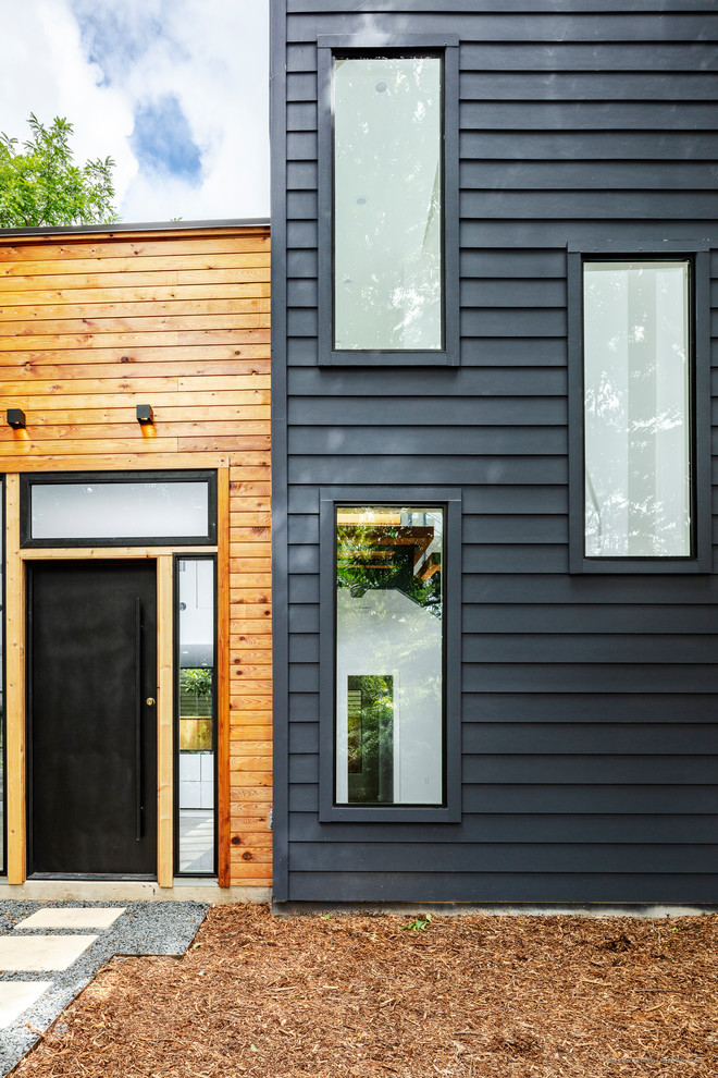 Example of a mid-sized minimalist white two-story wood flat roof design in Austin with a metal roof