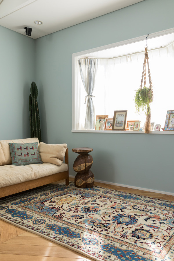 Cette image montre une salle à manger ouverte sur le salon chalet de taille moyenne avec un mur bleu, parquet clair, un sol beige et du papier peint.