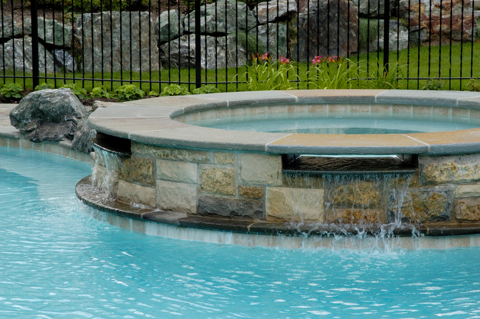 Large country backyard natural pool in Chicago with a hot tub and natural stone pavers.