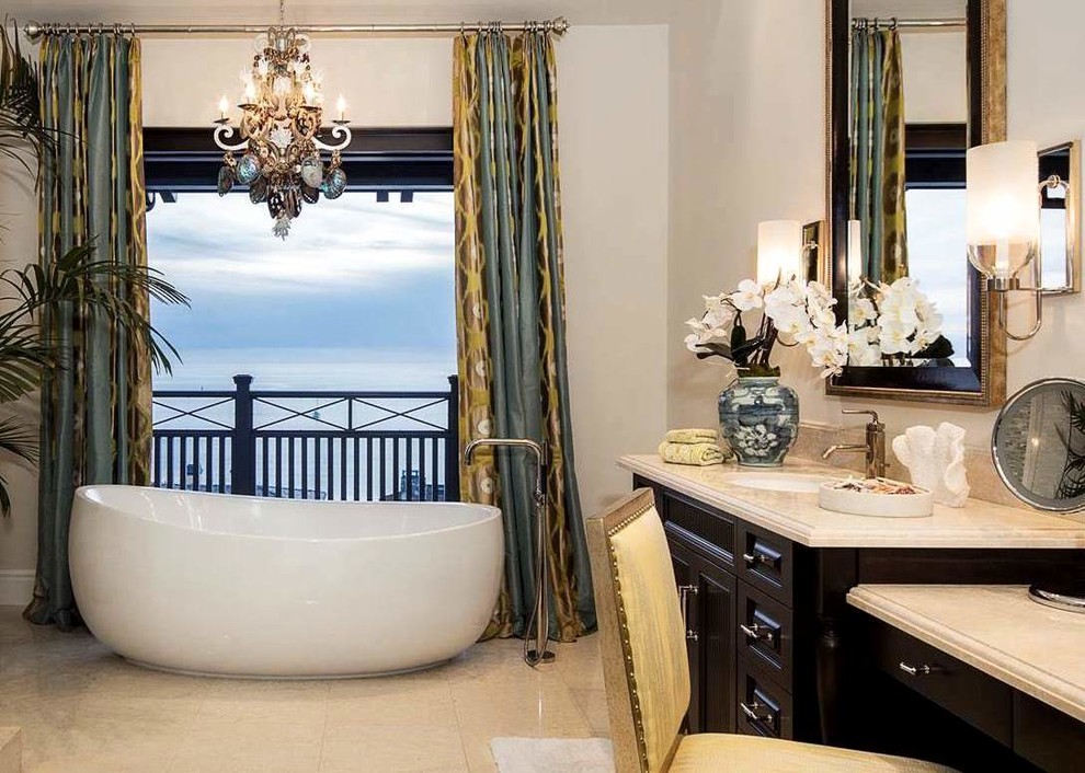 Design ideas for a large beach style master bathroom in Orange County with furniture-like cabinets, dark wood cabinets, a freestanding tub, stone tile, white walls, marble floors, an undermount sink and marble benchtops.