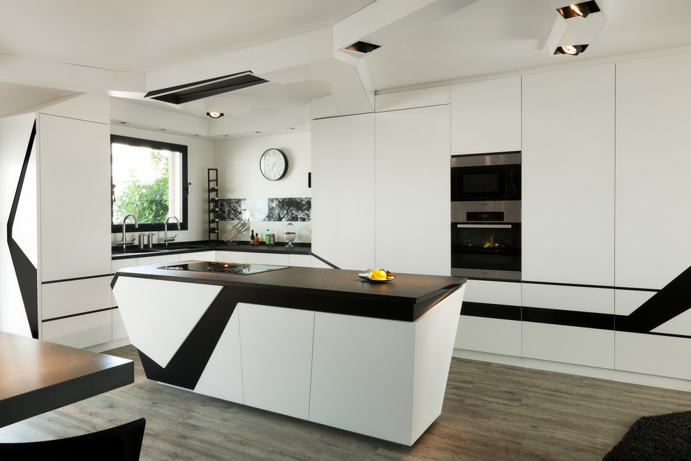 Photo of a large contemporary l-shaped open plan kitchen in Paris with a double-bowl sink, white cabinets, white splashback, stainless steel appliances, painted wood floors, with island, grey floor and black benchtop.