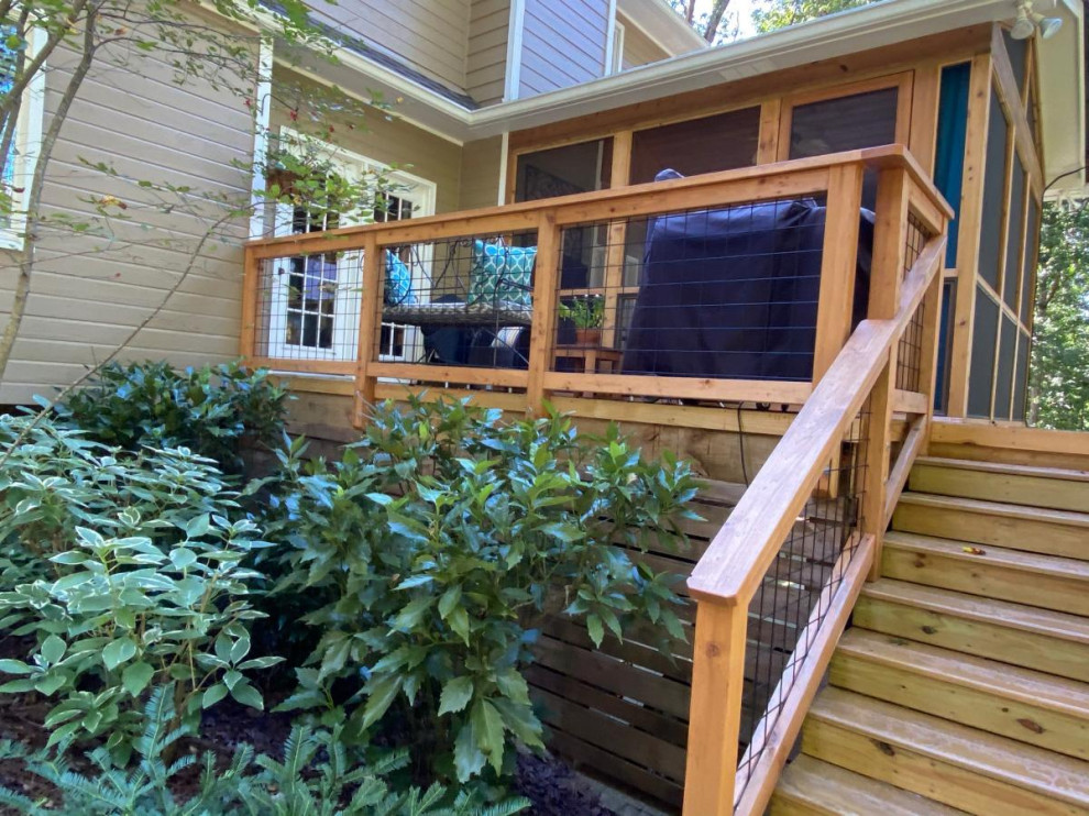 This is an example of a mid-sized country backyard deck in Birmingham with metal railing.