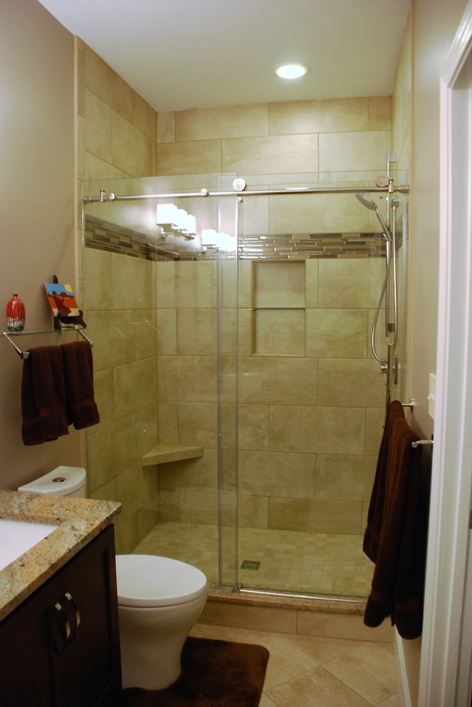 Idéer för att renovera ett mellanstort amerikanskt en-suite badrum, med luckor med infälld panel, skåp i mörkt trä, en dusch i en alkov, en toalettstol med separat cisternkåpa, beige kakel, porslinskakel, beige väggar, klinkergolv i porslin, ett undermonterad handfat och granitbänkskiva