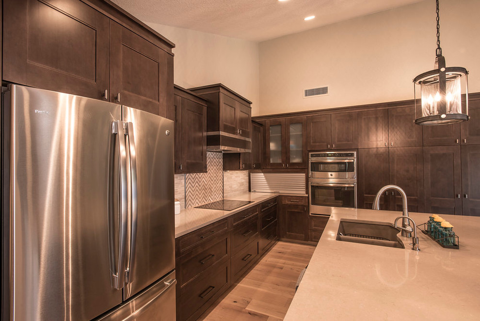 Example of a large transitional l-shaped light wood floor eat-in kitchen design in Phoenix with an undermount sink, shaker cabinets, dark wood cabinets, quartz countertops, beige backsplash, matchstick tile backsplash, stainless steel appliances and an island