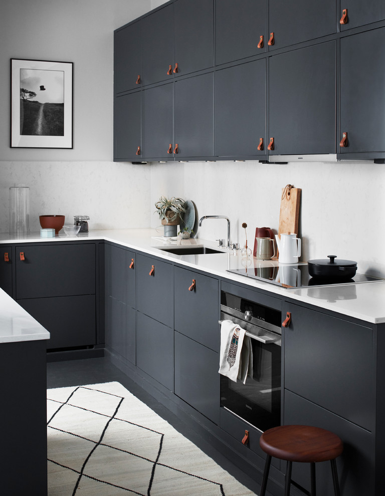 This is an example of a mid-sized contemporary l-shaped kitchen in Malmo with with island, an undermount sink, flat-panel cabinets, white splashback, black appliances, marble benchtops and grey cabinets.