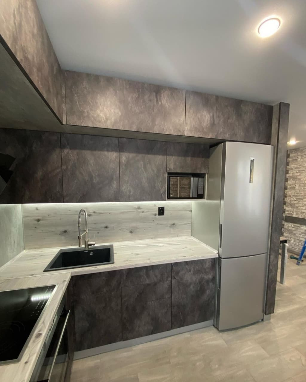 Встроенная черная угловая кухня в стиле лофт с бутылочницей