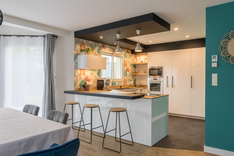 Photo of a mid-sized modern u-shaped eat-in kitchen in Other with a single-bowl sink, flat-panel cabinets, white cabinets, wood benchtops, timber splashback, stainless steel appliances, a peninsula and recessed.