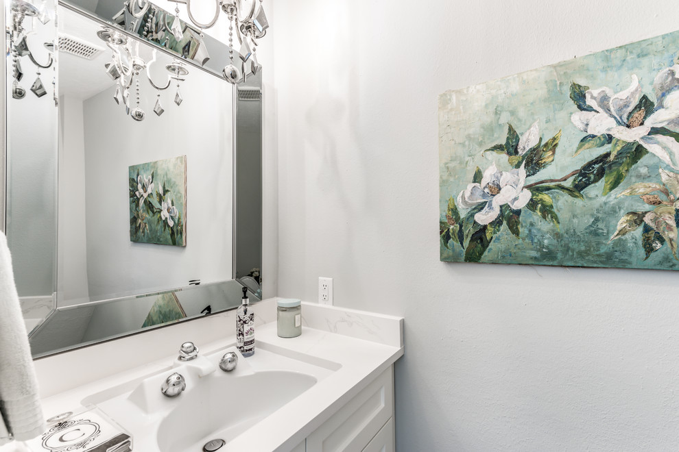 Photo of a small traditional powder room in Houston with shaker cabinets, white cabinets, a two-piece toilet, white tile, porcelain tile, grey walls, porcelain floors, an undermount sink, quartzite benchtops, brown floor and white benchtops.