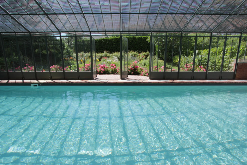 Design ideas for a mid-sized country indoor rectangular pool in Rennes with brick pavers.