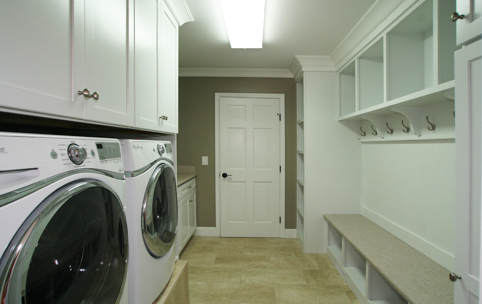 This is an example of a mid-sized transitional galley utility room in Cincinnati with shaker cabinets, white cabinets, laminate benchtops, brown walls, porcelain floors and a side-by-side washer and dryer.
