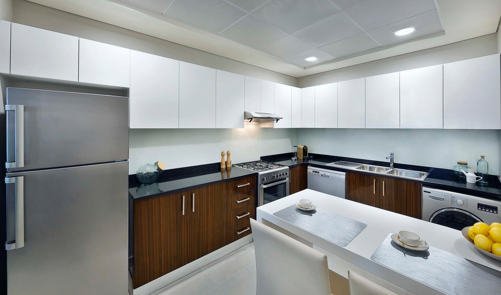 Photo of a small contemporary l-shaped separate kitchen in London with a double-bowl sink, shaker cabinets, medium wood cabinets, quartzite benchtops, white splashback, glass sheet splashback, stainless steel appliances, cement tiles, with island, beige floor and black benchtop.