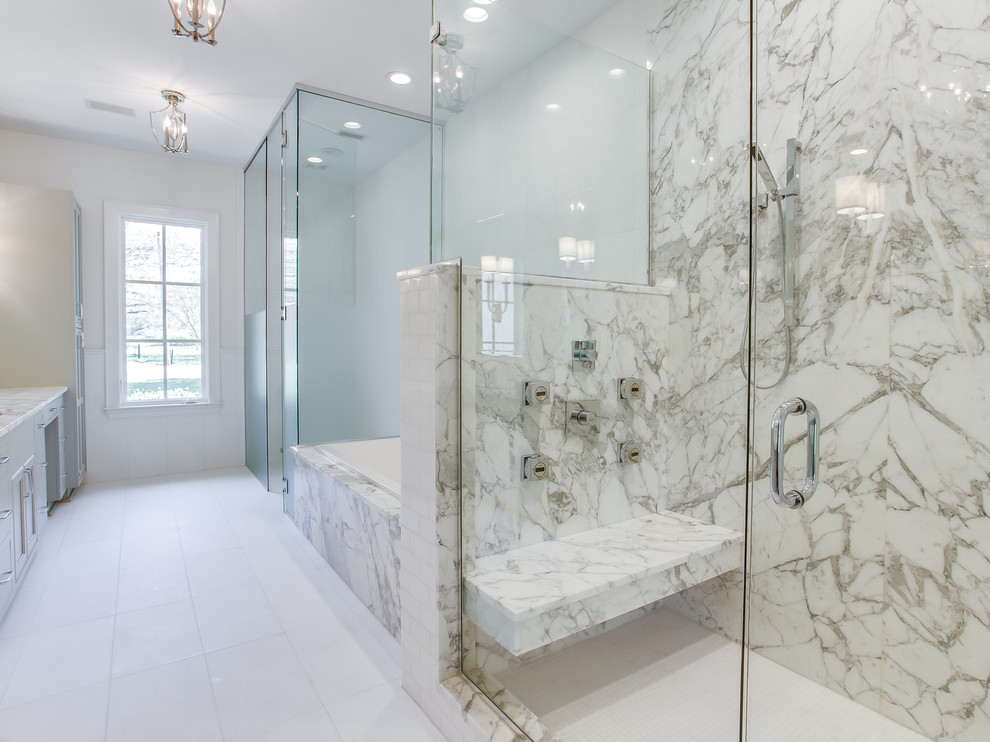 Large transitional master white tile and stone slab marble floor drop-in bathtub photo with beaded inset cabinets, gray cabinets, a one-piece toilet, gray walls, an undermount sink and marble countertops