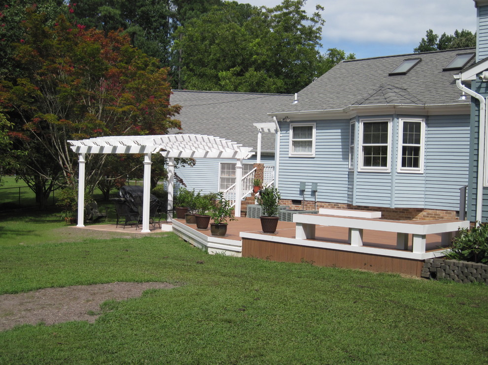 Example of a mid-sized transitional backyard deck design with a pergola