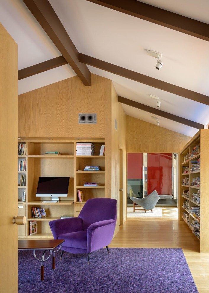 Design ideas for a mid-sized modern study room in San Diego with brown walls, light hardwood floors, no fireplace and a built-in desk.