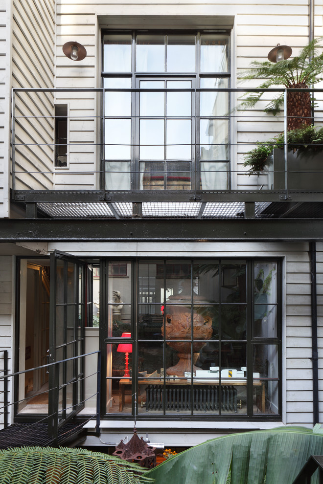 Design ideas for a traditional white exterior in London with wood siding.