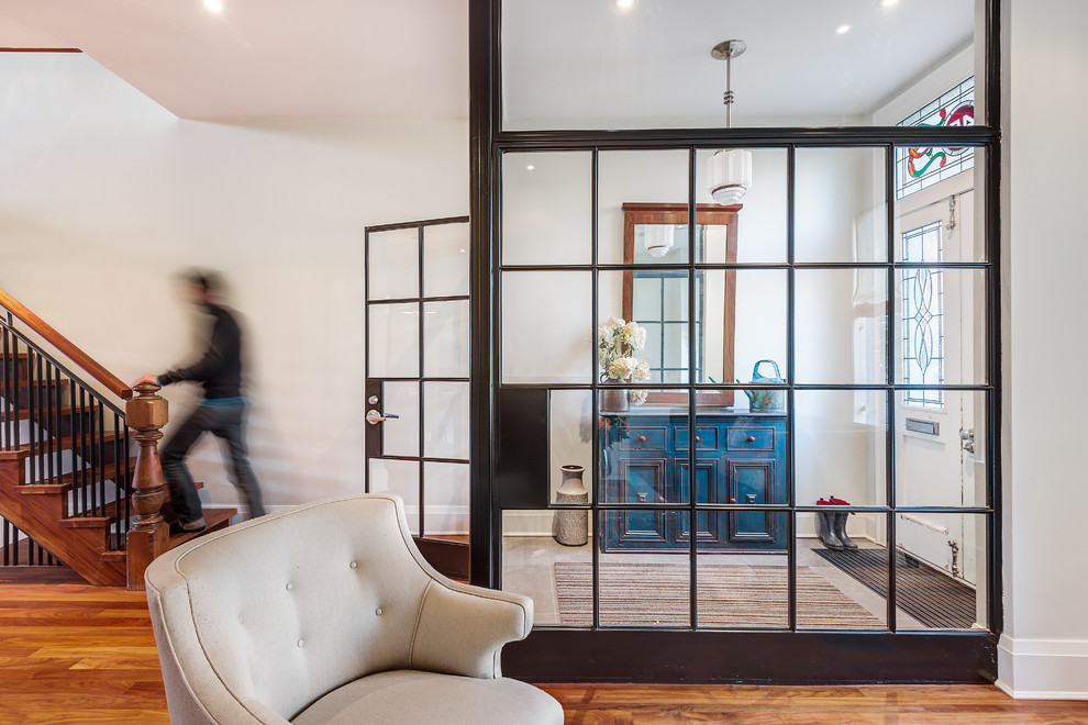 Photo of a mid-sized industrial foyer in Toronto with white walls, light hardwood floors, a single front door and a white front door.