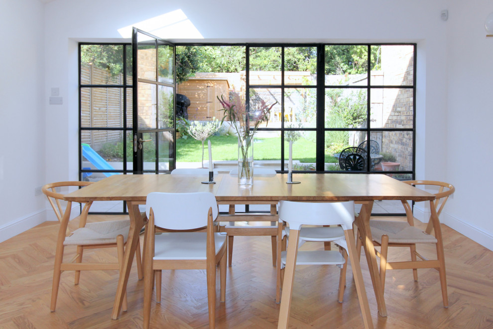 Réalisation d'une salle à manger ouverte sur le salon design de taille moyenne avec un mur blanc, un sol en bois brun et poutres apparentes.