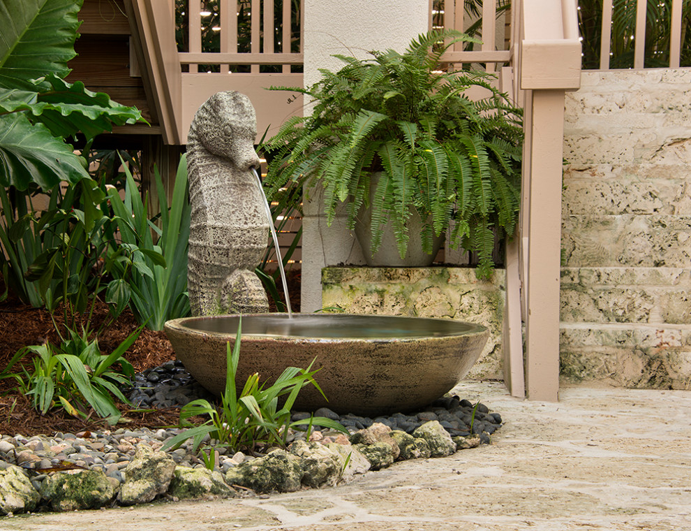 Design ideas for a large beach style courtyard partial sun garden for summer in Miami with a water feature.