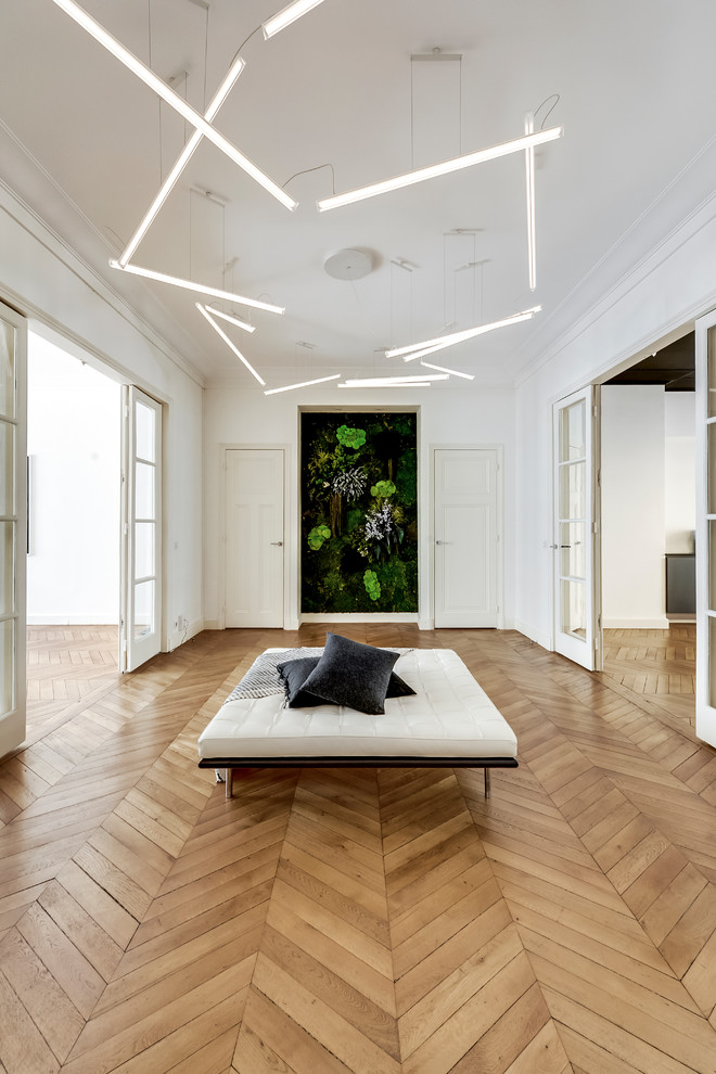 Large contemporary foyer in Paris with white walls, light hardwood floors and beige floor.