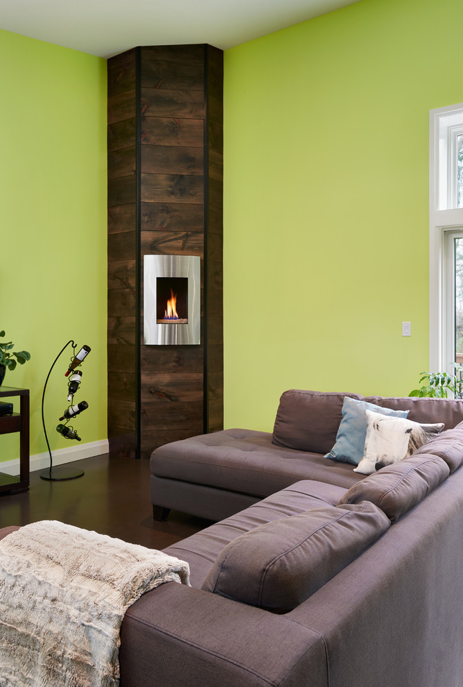 Inspiration for a mid-sized contemporary open concept living room in Toronto with green walls, concrete floors, a corner fireplace, a freestanding tv and a metal fireplace surround.